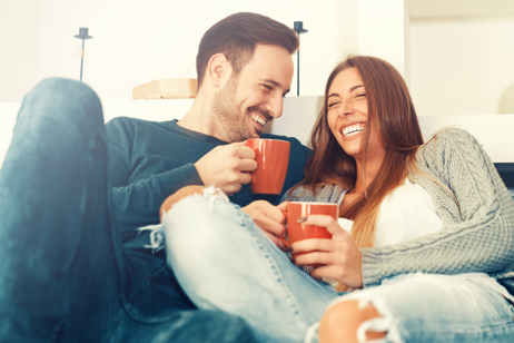 Couple laughs on couch together